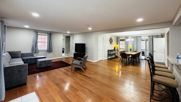 A spacious living area with a sofa, TV, and dining table.