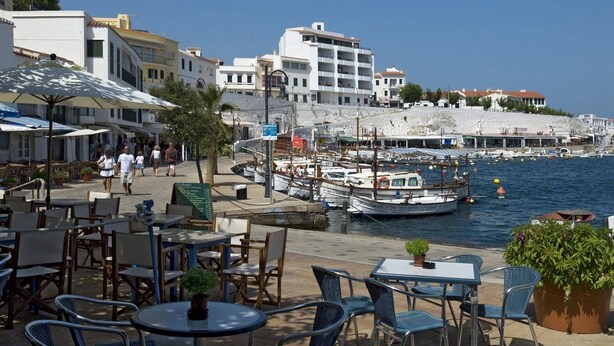 A coastal area with outdoor seating, boats, and buildings. - Villa Son Tretze by Villa Plus (Biniparrell)