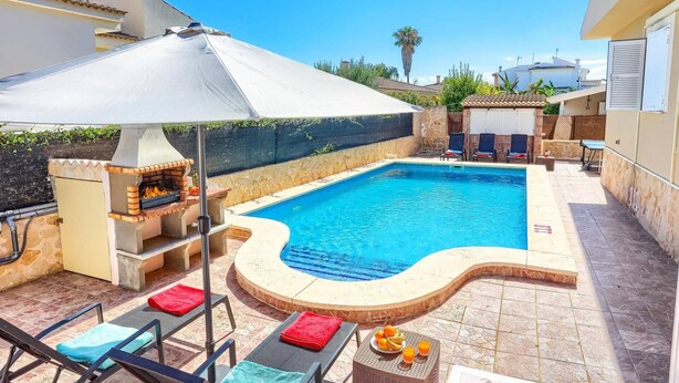 A swimming pool with a brick barbecue, lounge chairs, and a covered umbrella. - Villa Casa Galan by Villa Plus (Mallorca)