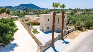 Une villa moderne dotée d’un toit plat, d’une piscine et offrant une vue sur la campagne environnante.