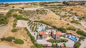 Villa Alnika Akazie mit Schwimmbad, mehreren Gebäuden und Blick auf die Küste.