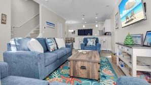Un salon moderne avec un canapé bleu, une table basse en bois et un tapis coloré.