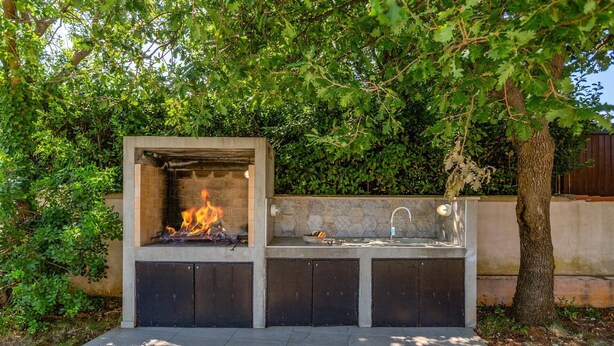 An outdoor kitchen with a built-in fire feature and a sink. - Villa Amalee by Villa Plus (Liznjan)