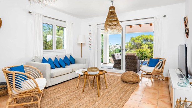 A bright living room with a sofa, chairs, a coffee table, and a TV. - Villa Anchorage by Villa Plus (Puerto Luz)