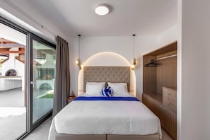 Quarto com cama grande, porta de correr para varanda, guarda-roupa de madeira e luminária no teto.