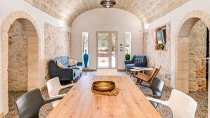 Una habitación amplia con una larga mesa de madera, dos sofás y una mesita redonda.