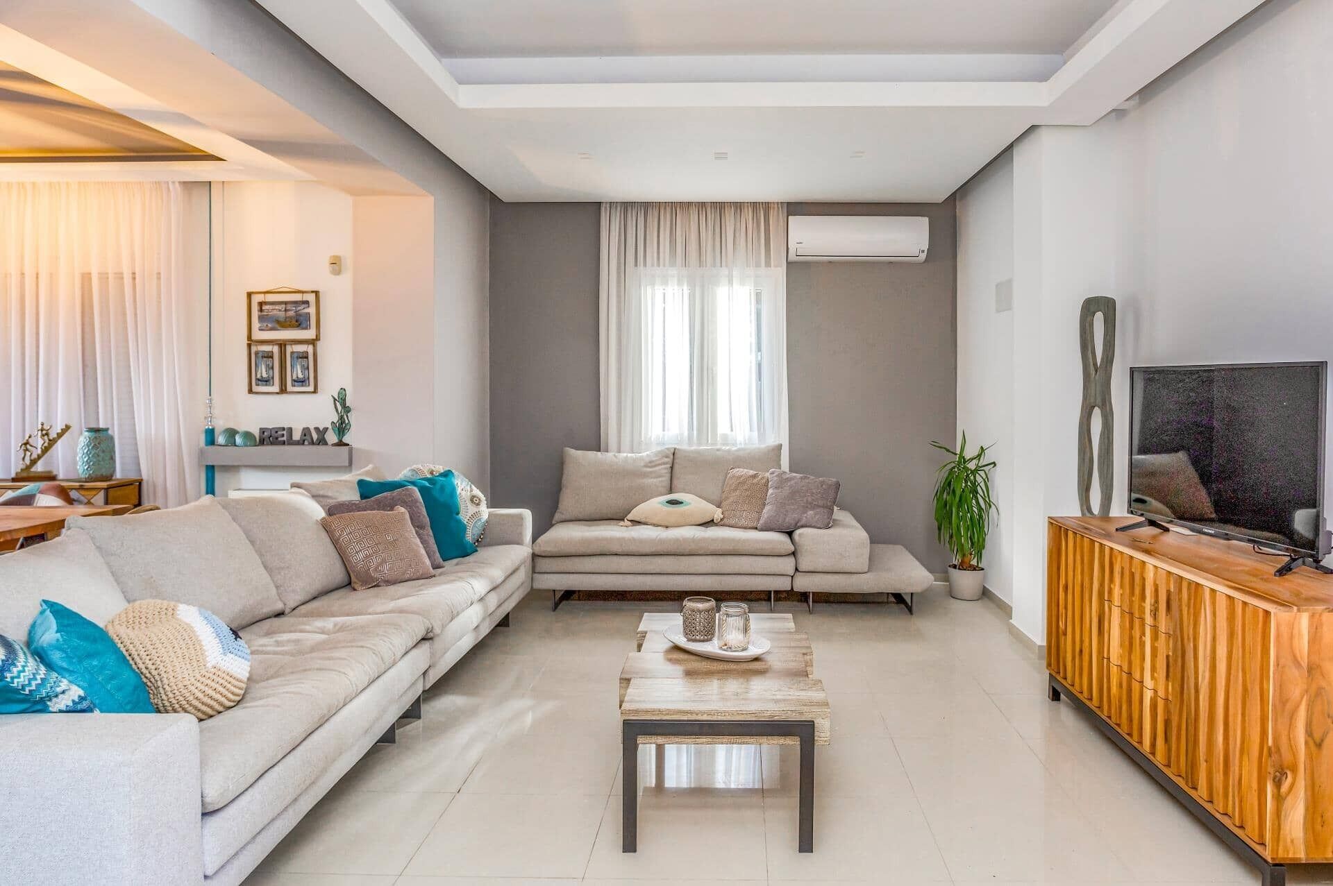 A modern living room with a sofa, coffee table, and TV stand.