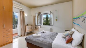 Ein Schlafzimmer mit Bett, Schrank, Kommode, einem Fenster mit Blick und einer Wand mit einer Karte.