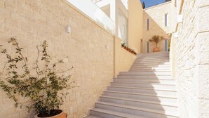 A narrow alleyway with a white staircase leading to a building with a modern design.