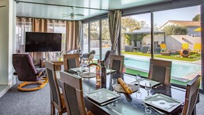 A dining area with a view of a swimming pool and outdoor seating. - Villa Bohemienne by Villa Plus (Plaissan)