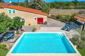 A rectangular swimming pool with a clear blue water surface, surrounded by a white fence.