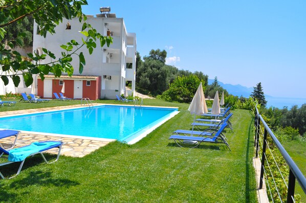 Relax by the pool surrounded by lush greenery and scenic views of the distant mountains.