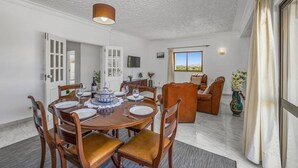 Un espace repas comprenant une table ronde, des chaises et un luminaire au plafond.