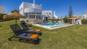 A modern villa with a swimming pool, sun loungers, and a thatched umbrella. - Villa Casa Duarte by Villa Plus (Olhos de Água)