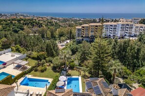 Un quartier résidentiel doté d’une piscine, de panneaux solaires et offrant une vue sur la mer.