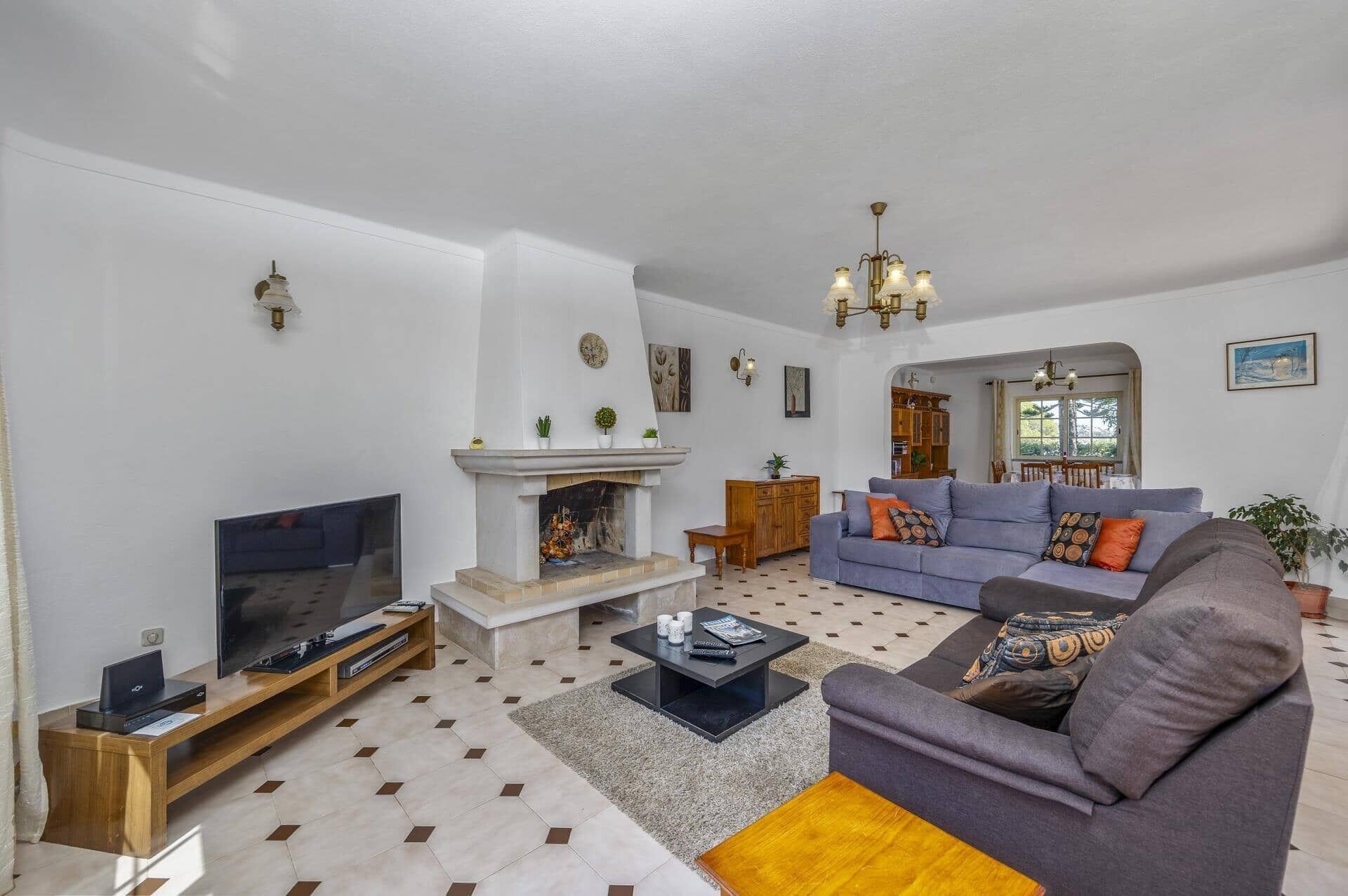 A living room with a fireplace, a sofa, a TV, and a coffee table.