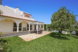 A house with a patio, a pool, and a large tree. - Villa Casa Pimenteira by Villa Plus (Lagoa)