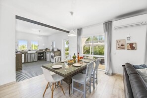 Enjoy meals at the dining table for four, surrounded by comfortable seating and a large window offering a view of the outdoors.