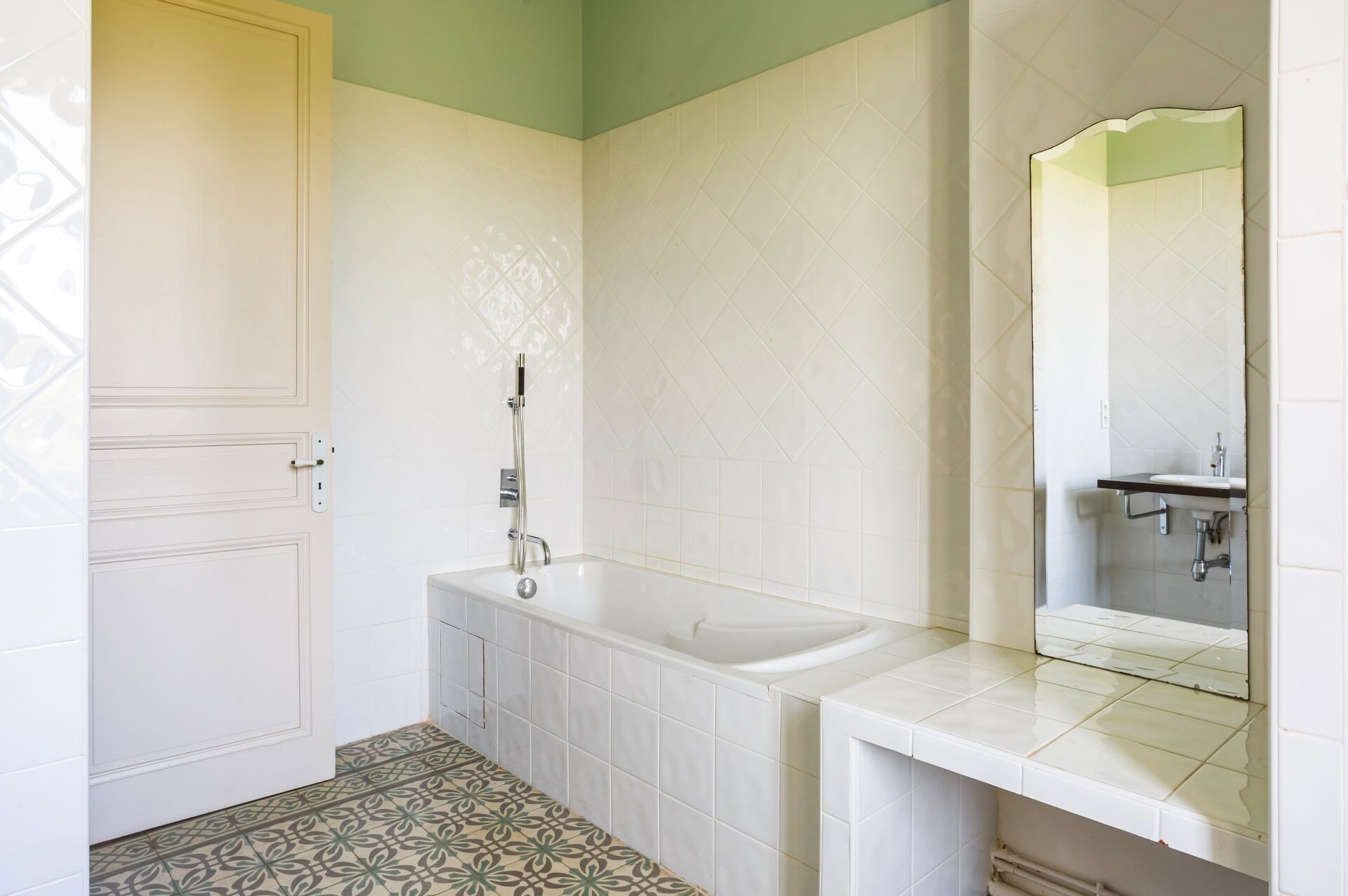 Une salle de bain avec une baignoire, un lavabo et un miroir.