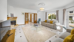 Uma sala de estar moderna com lareira, sofá, mesa de centro e televisão.