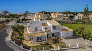 Uma área residencial costeira com casas de arquitetura mediterrânea, incluindo telhados em cerâmica e paredes brancas.