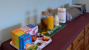 A breakfast buffet setup with cereal boxes, juice, and condiments. - Orchard house bed and breakfast (Swindon)