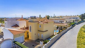 A residential area with multiple buildings, a swimming pool, and a paved road. - Villa Graca by Villa Plus (Albufeira)