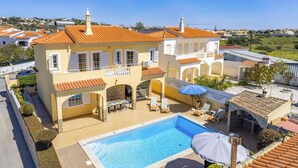 A two-story building with a swimming pool, outdoor seating, and a view of the surrounding neighborhood. - Villa Graca by Villa Plus (Albufeira)