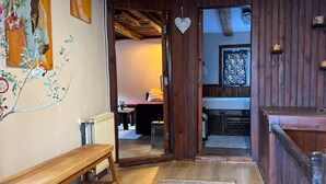 Een houten interieur met een bank, een vloerkleed en een hartvormige decoratie aan de muur.
