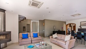 A modern living room with two sofas, a coffee table, and a fireplace. - Villa Karlia by Villa Plus (Vale Rebelho)