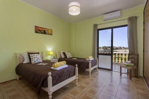 Ein Hotelzimmer mit zwei Betten, einem Balkon und Blick auf die Landschaft.