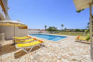 A swimming pool with lounge chairs and a tiled deck. - Villa Luis Gale by Villa Plus (Vale Rebelho)