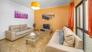A living room with a sofa, a coffee table, a TV, and artwork on the walls. - Villa Luis Gale by Villa Plus (Vale Rebelho)