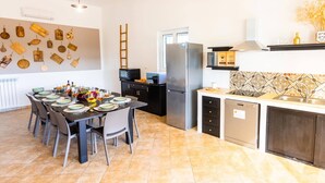 A modern kitchen with a dining area, featuring a refrigerator, microwave, and dishwasher. - Villa Maria Rosaria by Villa Plus (Ceglie Messapica)