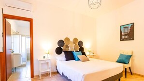 A hotel room with a bed, bedside tables, a chair, and a wall-mounted artwork. - Villa Maria Rosaria by Villa Plus (Ceglie Messapica)