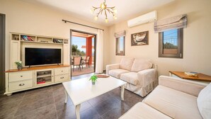 Ein Wohnzimmer mit Fernseher, Sofa und Couchtisch.