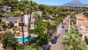 A residential area with a pool, palm trees, and a mountain in the background. - Villa Murales by Villa Plus (El Tosalet)