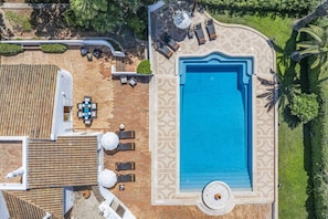 An aerial view of a property with a swimming pool, lounge chairs, a table, and a covered seating area. - Villa Pinehill by Villa Plus (Praia do Carvoeiro)