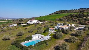 Una extensa propiedad con varias construcciones, piscina y un paisaje montañoso.