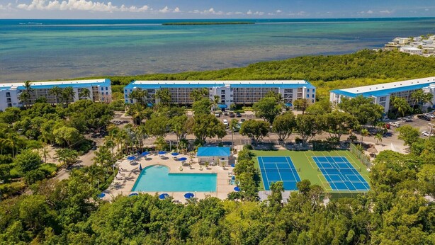 A resort with multiple buildings, a swimming pool, tennis courts, and a view of the ocean. - Relax in your one bedroom Oceanfront Suite in Tavernier FL. Florida Keys. (Tavernier)