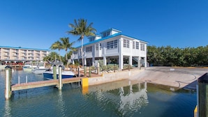 A waterfront hotel with a pool, boats, and a palm tree. - Relax in your one bedroom Oceanfront Suite in Tavernier FL. Florida Keys. (Tavernier)