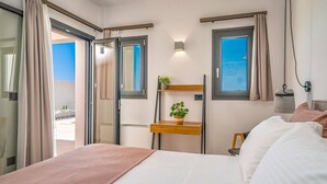 A hotel room with a bed, a small wooden table with a plant, a window, and a view of the outside.
