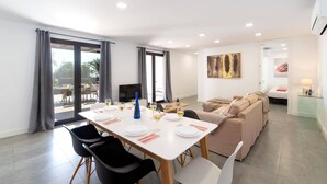 A modern living room with a dining area, a sofa, and a TV. - Villa Taiga by Villa Plus (Playa Blanca)