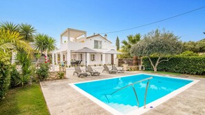 A modern house with a swimming pool, outdoor seating, and lush greenery. - Villa Zante Pnoe by Villa Plus (Pantokratoras)