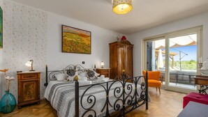 A bedroom with a bed, a wardrobe, a desk, and a view of the outdoors. - Villa Principe by Villa Plus (Groznjan)