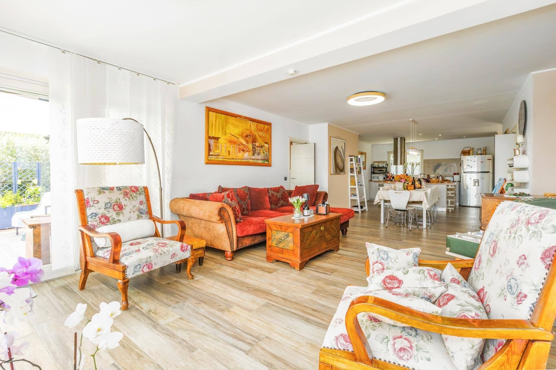 A spacious living area with a sofa, chairs, a coffee table, and a dining table set for four.