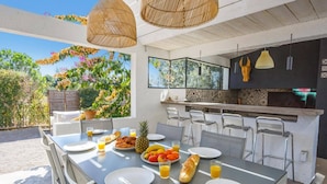 An outdoor dining area with a table set for breakfast, including croissants, fruit, and juice. - Villa Saffron by Villa Plus (Villedaigne)
