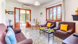 A cozy living room with a dining area, large windows, and a view of the outdoors.