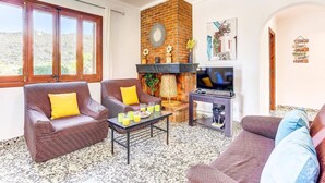 A living room with two sofas, a coffee table, a TV, and a fireplace.