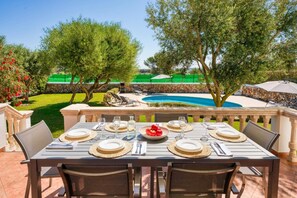 Enjoy al fresco dining with a view of the pool and garden.